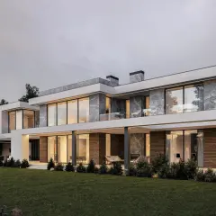 Nowoczesny, luksusowy dom z dużymi oknami i ceglaną elewacją, otoczony zielonym ogrodem.