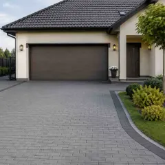 Nowoczesny podjazd z kostki brukowej, świetny pomysł na tani podjazd. Elegancki dom z garażem i zadbanym ogrodem.