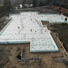 Budowa fundamentów na płytach izolacyjnych. Widać zbrojenie i rury, przygotowanie pod betonowanie na gruncie spoistym.