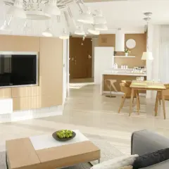 Nowoczesna zabudowa pod telewizor z karton gipsu, z frontami imitującymi drewno, tworzy elegancką przestrzeń w salonie.