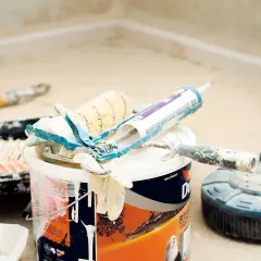 Narzędzia malarskie, puszka farby i pistolet do silikonu. Czy zapach farby jest szkodliwy? To pytanie zadaje sobie wielu majsterkowiczów.
