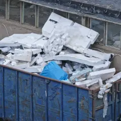 Duży kontener z gruzem, w tym biały styropian. Zastanawiasz się, gdzie wyrzucić styropian? Ten kontener to dobry początek.