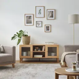 Jasne, oto opis:

Przytulny salon z jasnymi, neutralnymi kolorami ścian. Wygodne fotele, drewniana komoda i dekoracje tworzą spokojną atmosferę.