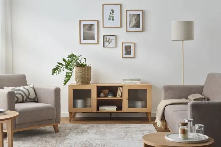 Jasne, oto opis:

Przytulny salon z jasnymi, neutralnymi kolorami ścian. Wygodne fotele, drewniana komoda i dekoracje tworzą spokojną atmosferę.