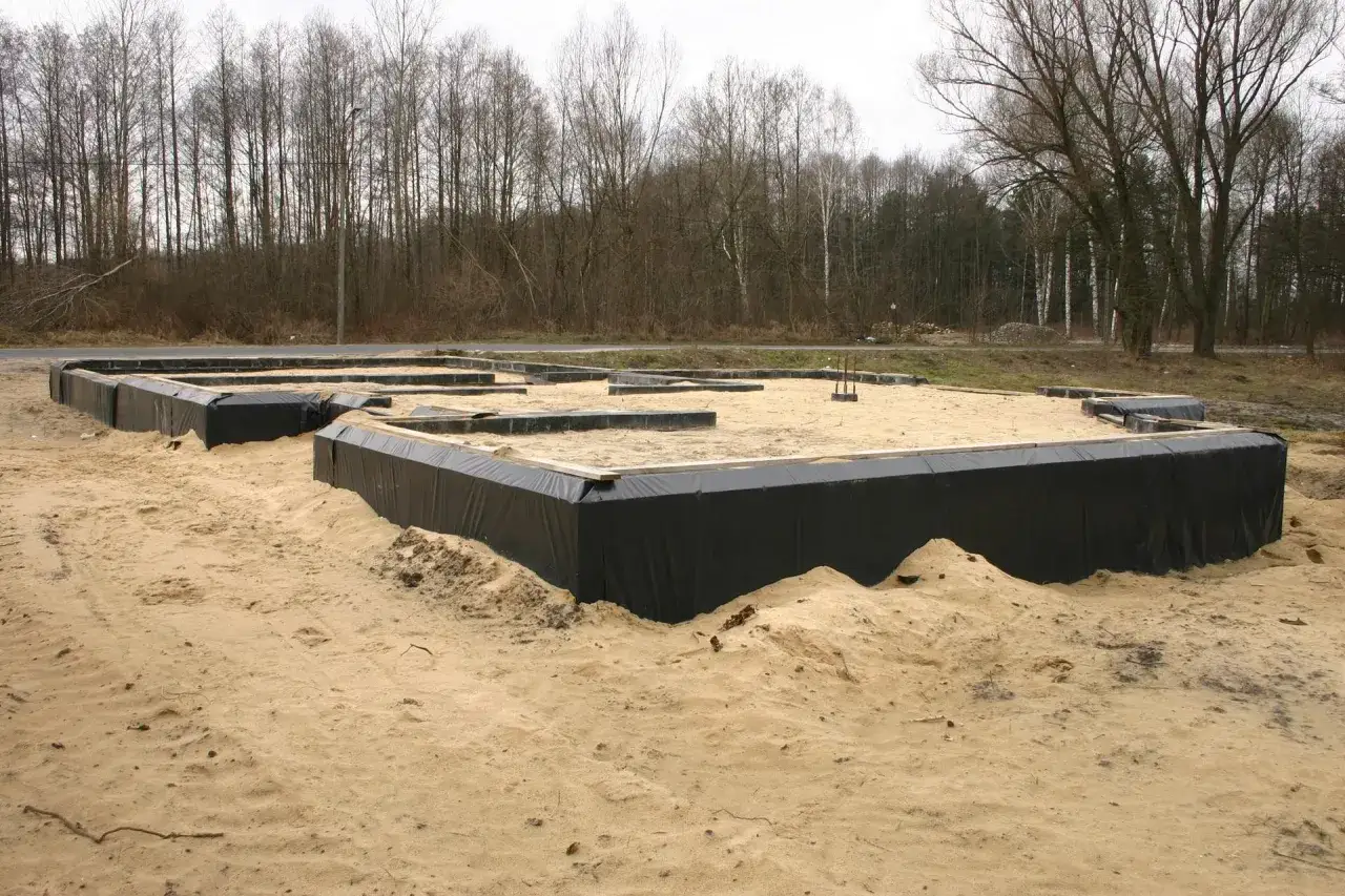 Fundament domu w piasku, gotowy do dalszych prac. To pierwszy krok, od czego zacząć budowę domu.